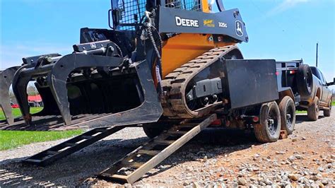 loading a skid steer on over the axle dump trailer|dump trailer loading skid steer.